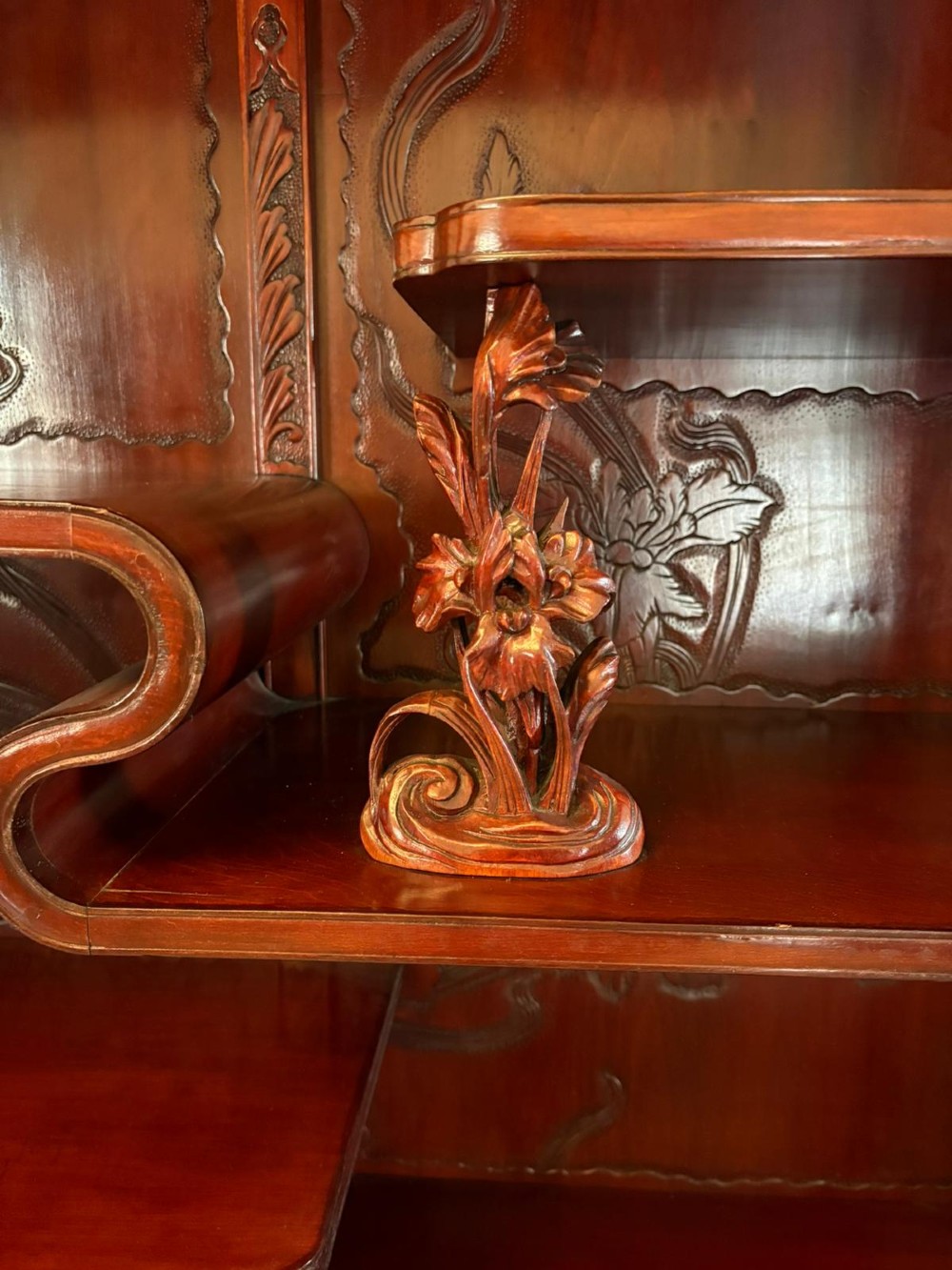 A carved reddish-brown hardwood display cabinet featuring a pagoda cresting, glass door, asymmetrical interior shelves, lower drawers, and cabriole legs. View XI