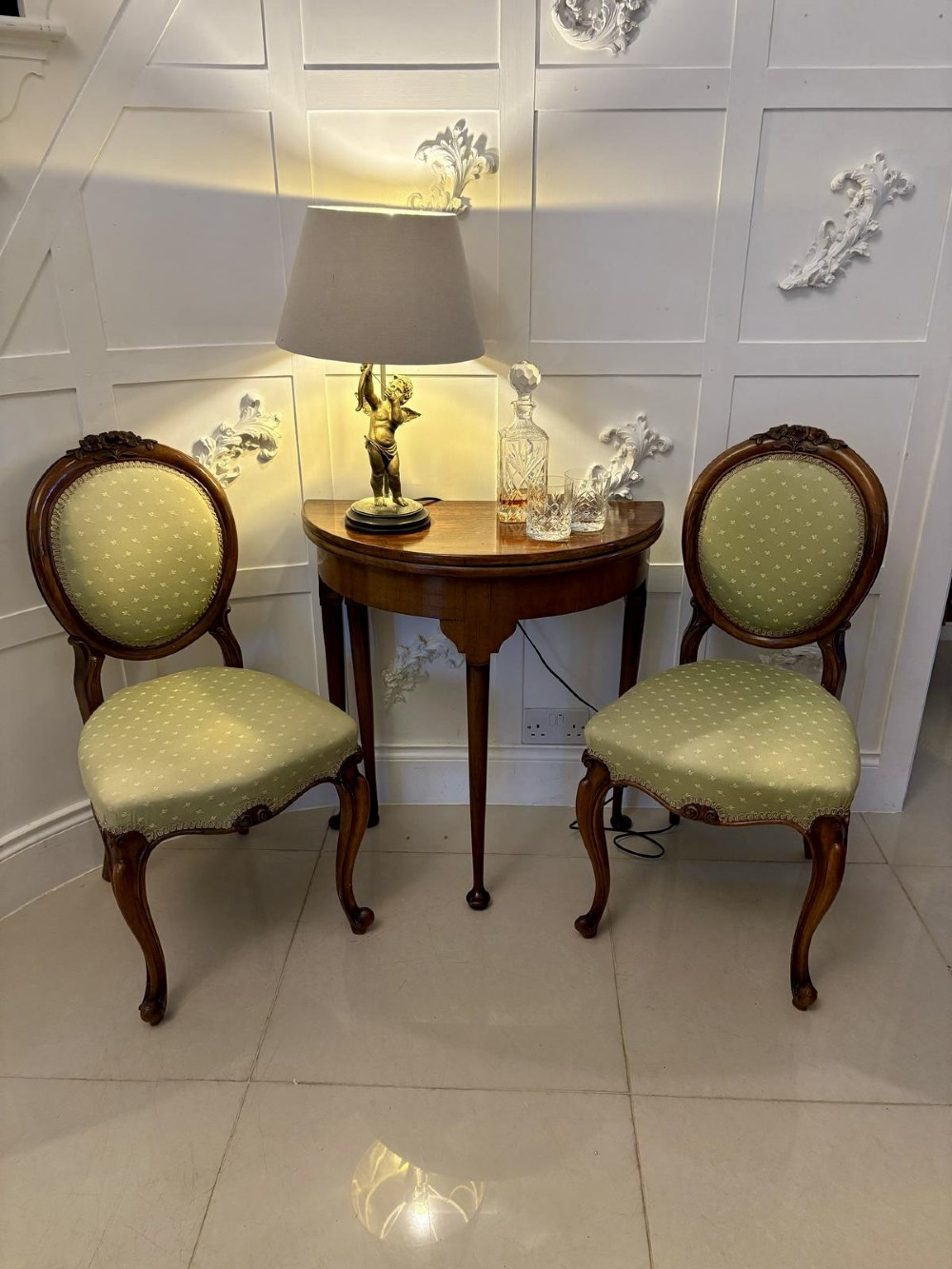 An antique warm brown mahogany demi-lune card table featuring tapered legs with pad feet and a fold-over top. View II