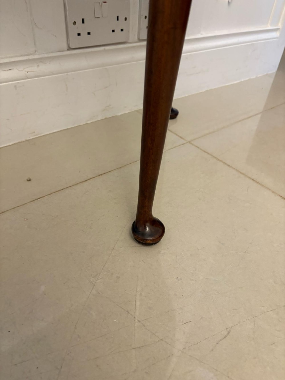 An antique warm brown mahogany demi-lune card table featuring tapered legs with pad feet and a fold-over top. View IV