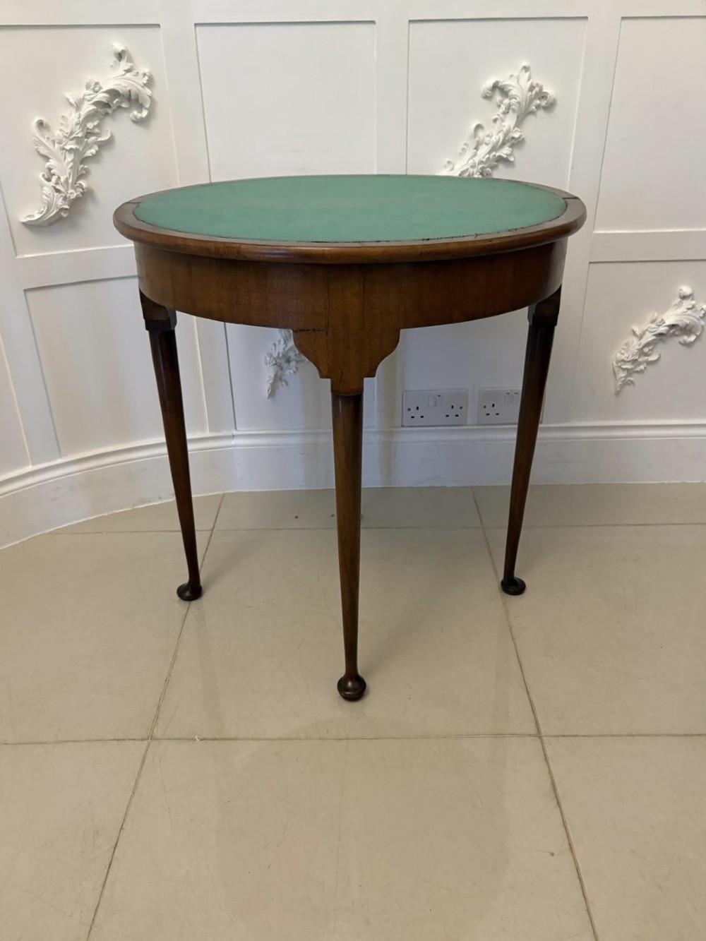 An antique warm brown mahogany demi-lune card table featuring tapered legs with pad feet and a fold-over top. View VIII