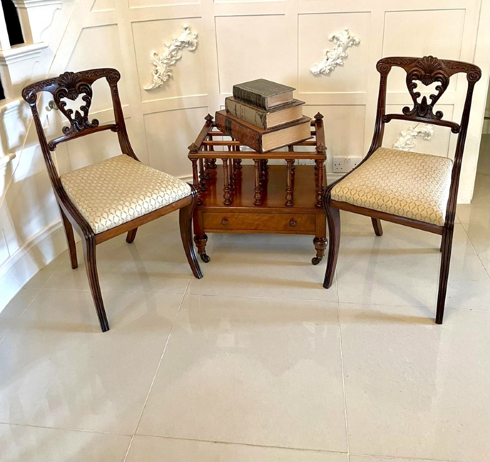 A Victorian figured walnut Canterbury featuring multiple vertical turned spindles, corner finials, a lower base drawer with two knobs, and brass castors. View III
