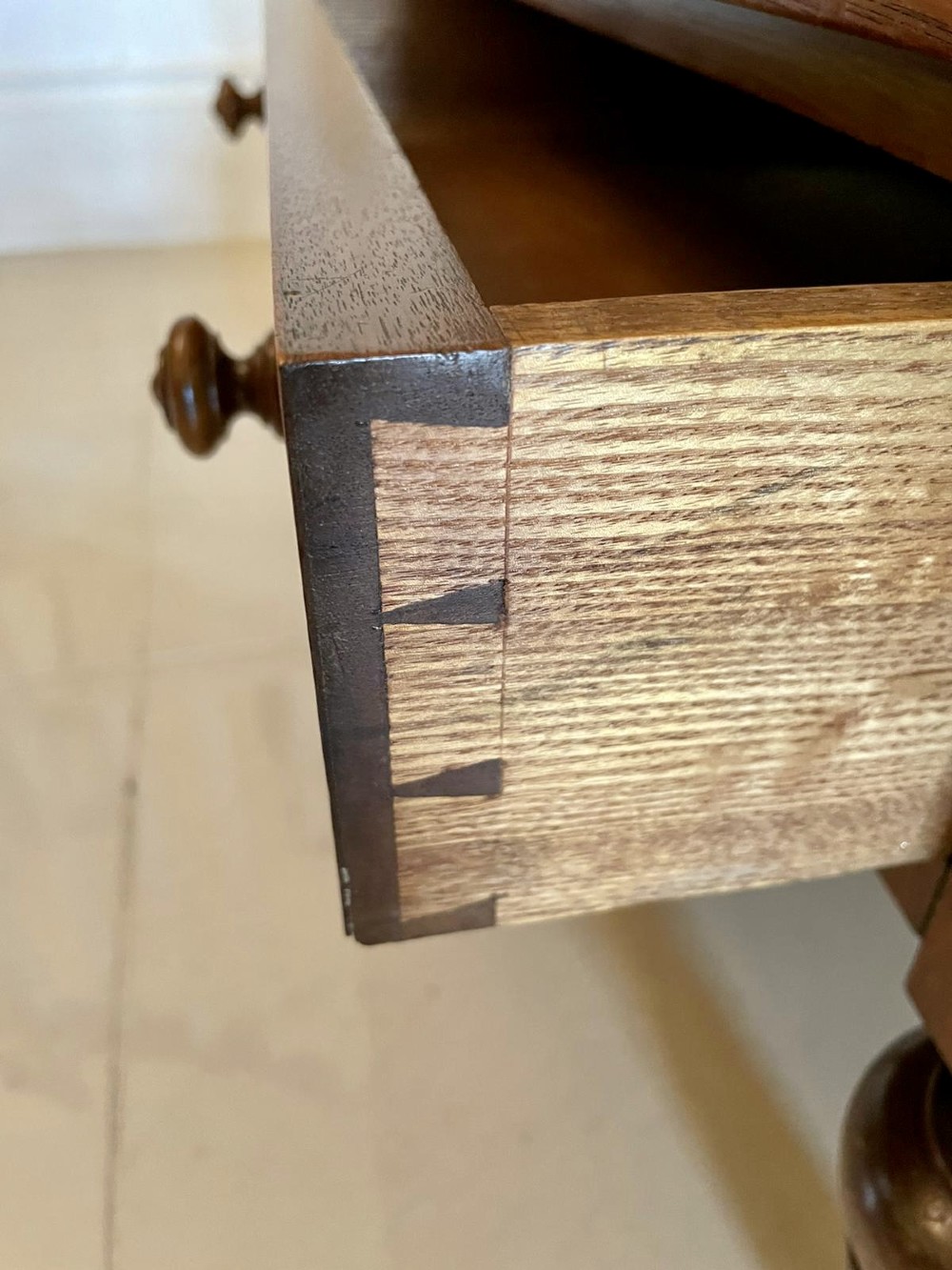 A Victorian figured walnut Canterbury featuring multiple vertical turned spindles, corner finials, a lower base drawer with two knobs, and brass castors. View XI