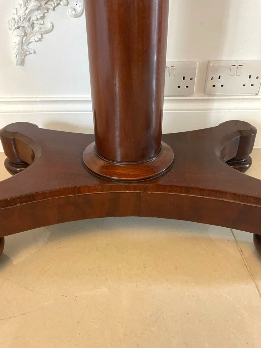 A Victorian mahogany card table featuring a rectangular fold-over top, carved scroll apron brackets, and a central cylindrical pedestal on a four-point plinth base. View VII
