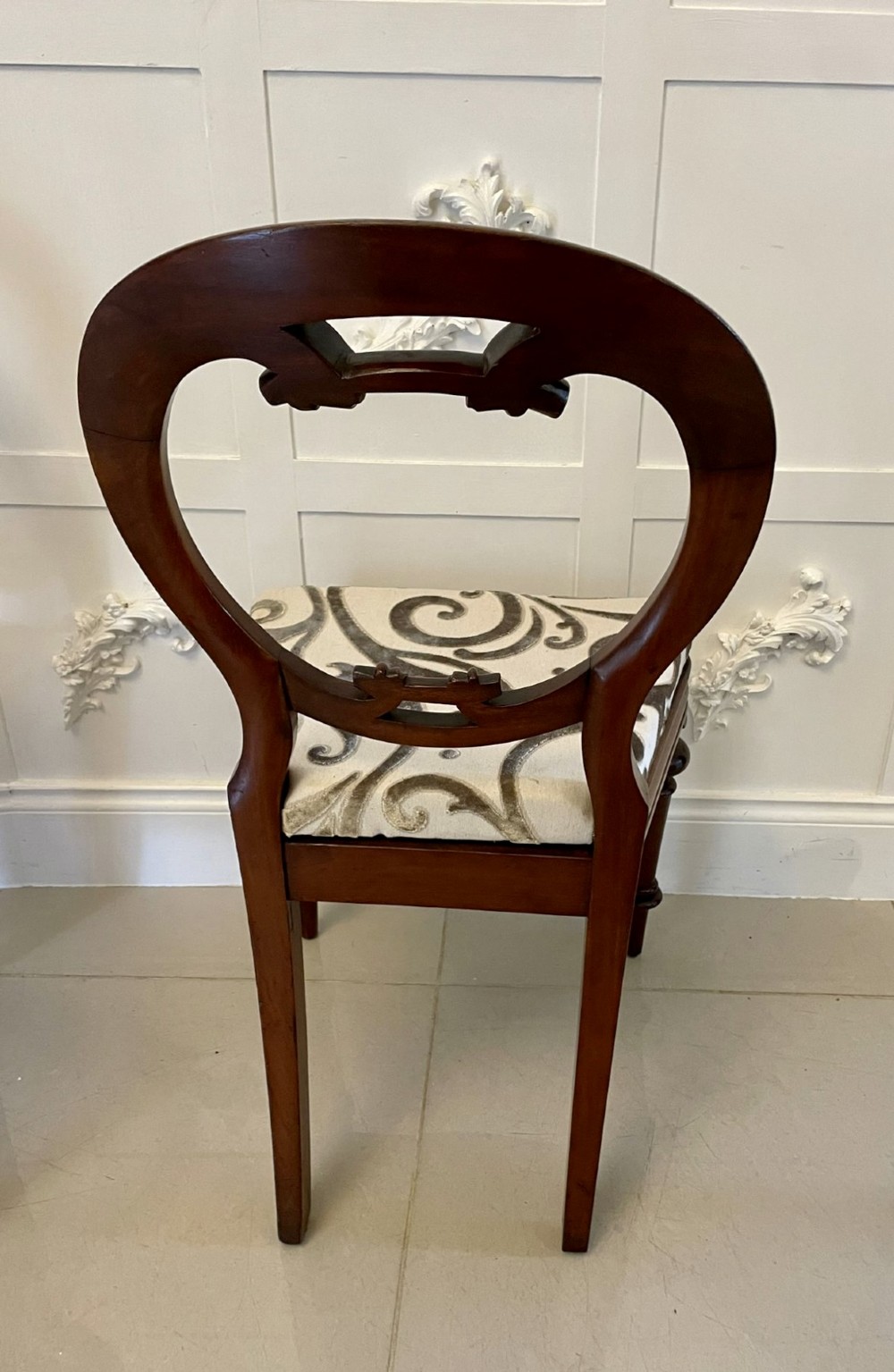 A set of six Victorian mahogany dining chairs featuring rounded balloon backrests, carved mid-rails, patterned upholstery, and turned front legs. View II