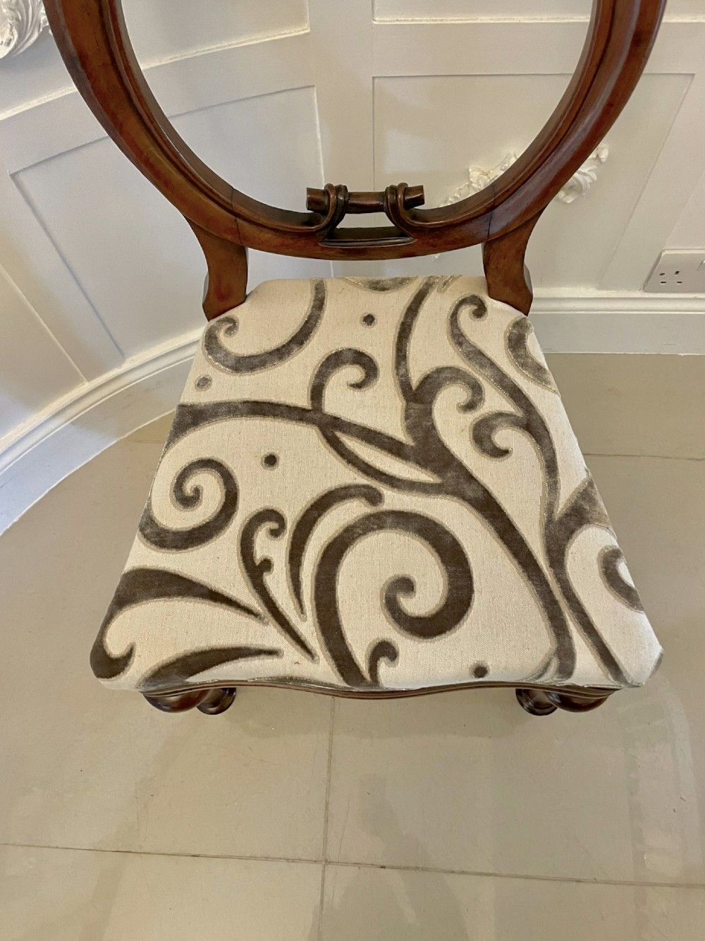 A set of six Victorian mahogany dining chairs featuring rounded balloon backrests, carved mid-rails, patterned upholstery, and turned front legs. View III