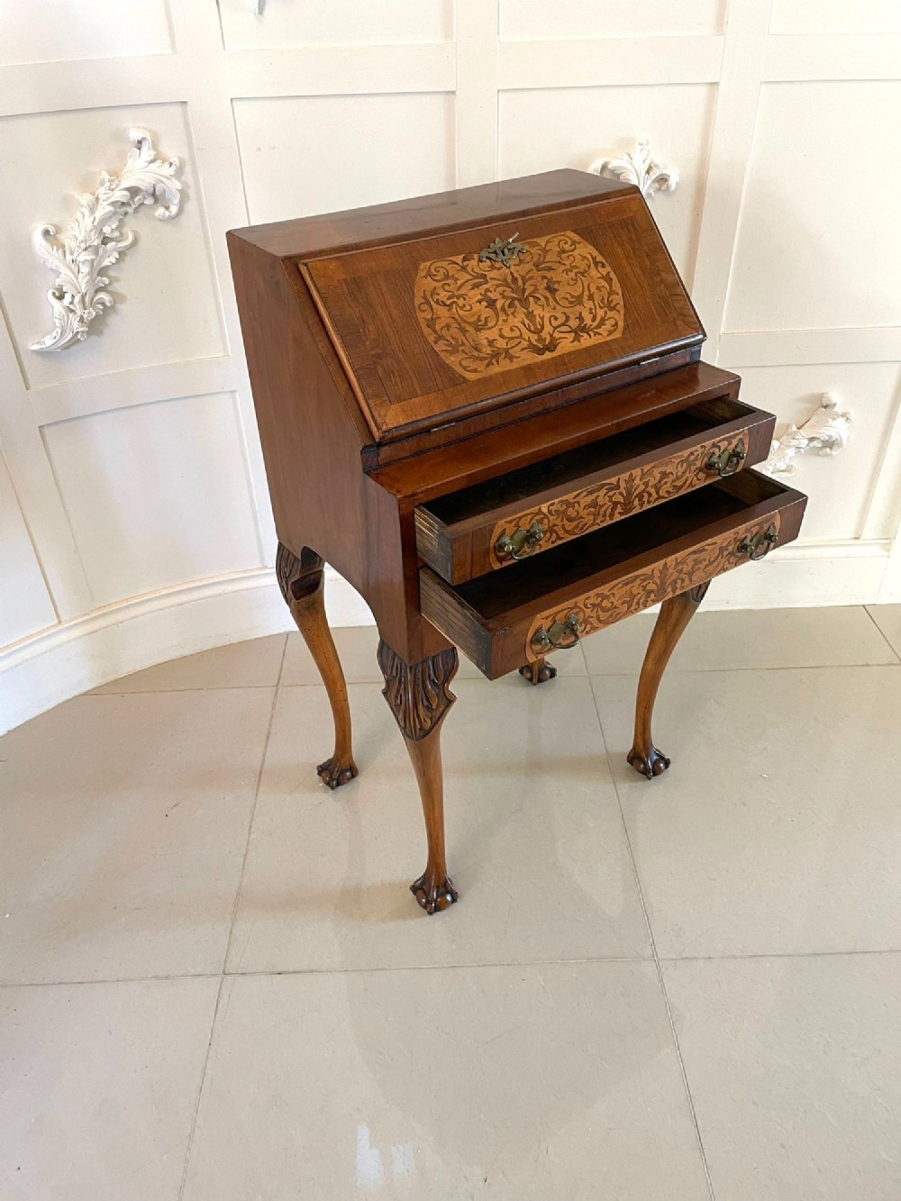 An antique burr walnut slant-front bureau featuring central floral marquetry inlay, two drawers, and carved cabriole legs with claw and ball feet. View IV