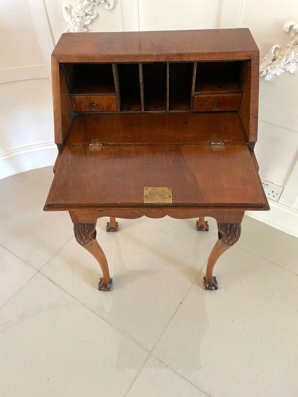 An antique burr walnut slant-front bureau featuring central floral marquetry inlay, two drawers, and carved cabriole legs with claw and ball feet. View VI