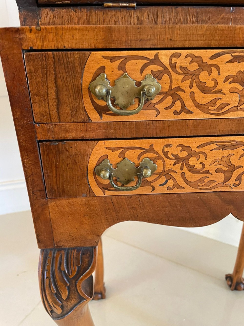 An antique burr walnut slant-front bureau featuring central floral marquetry inlay, two drawers, and carved cabriole legs with claw and ball feet. View VII