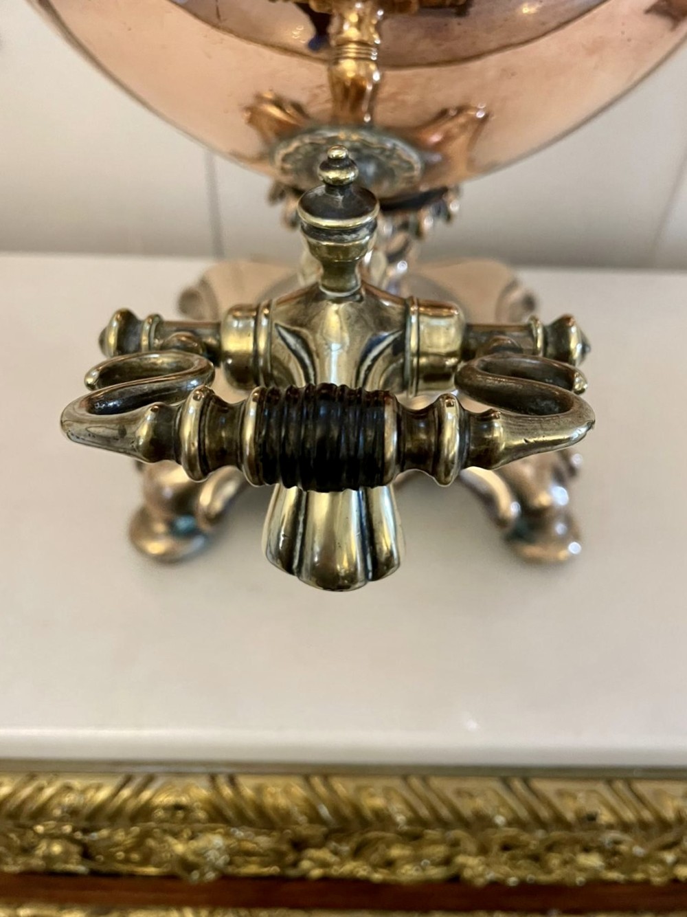 An antique Victorian polished copper and brass samovar featuring cast scrolling handles, a fluted top lid, a front tap, and a stepped square base. View VI
