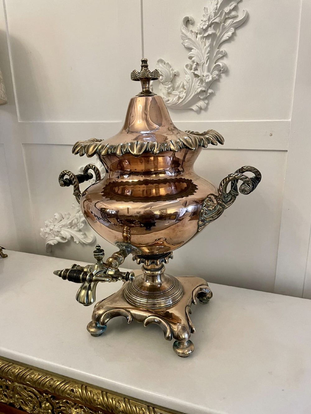 An antique Victorian polished copper and brass samovar featuring cast scrolling handles, a fluted top lid, a front tap, and a stepped square base. View VIII