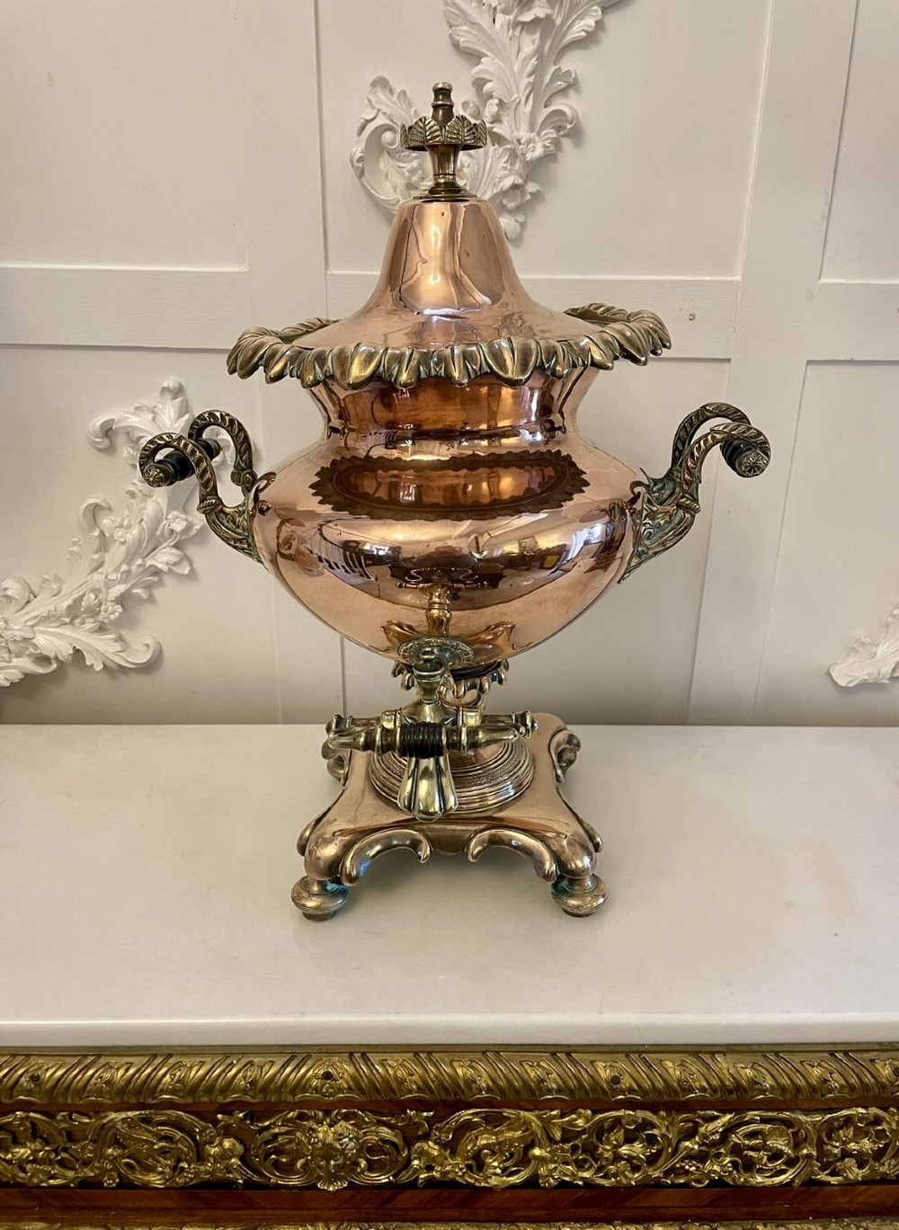 An antique Victorian polished copper and brass samovar featuring cast scrolling handles, a fluted top lid, a front tap, and a stepped square base. View IX