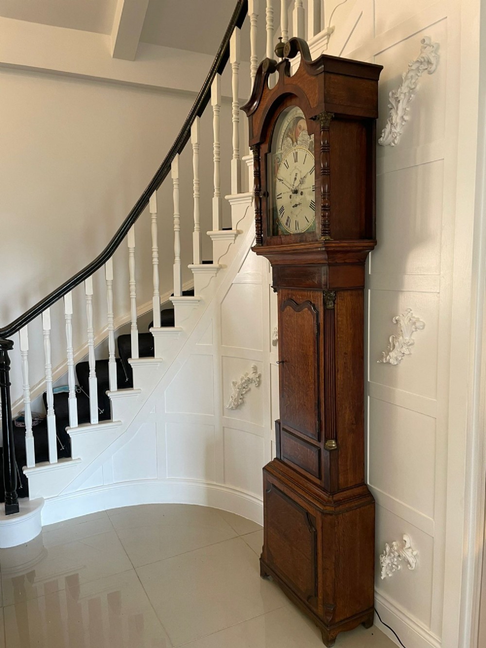 An antique George III oak and mahogany longcase clock with a swan-neck pediment, reeded columns, and a painted moon phase dial. View VII
