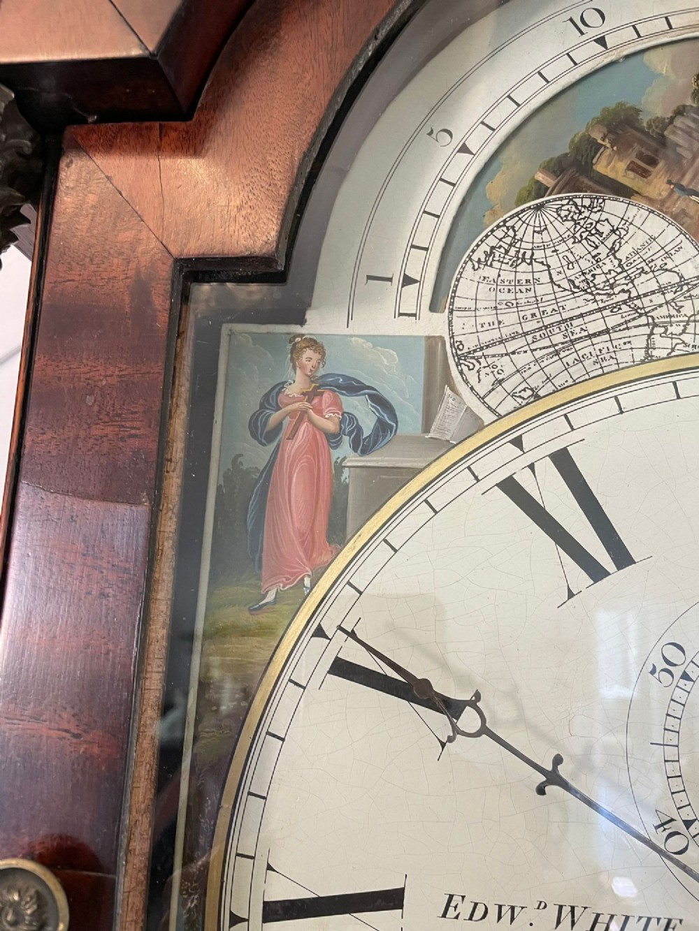An antique George III oak and mahogany longcase clock with a swan-neck pediment, reeded columns, and a painted moon phase dial. View X
