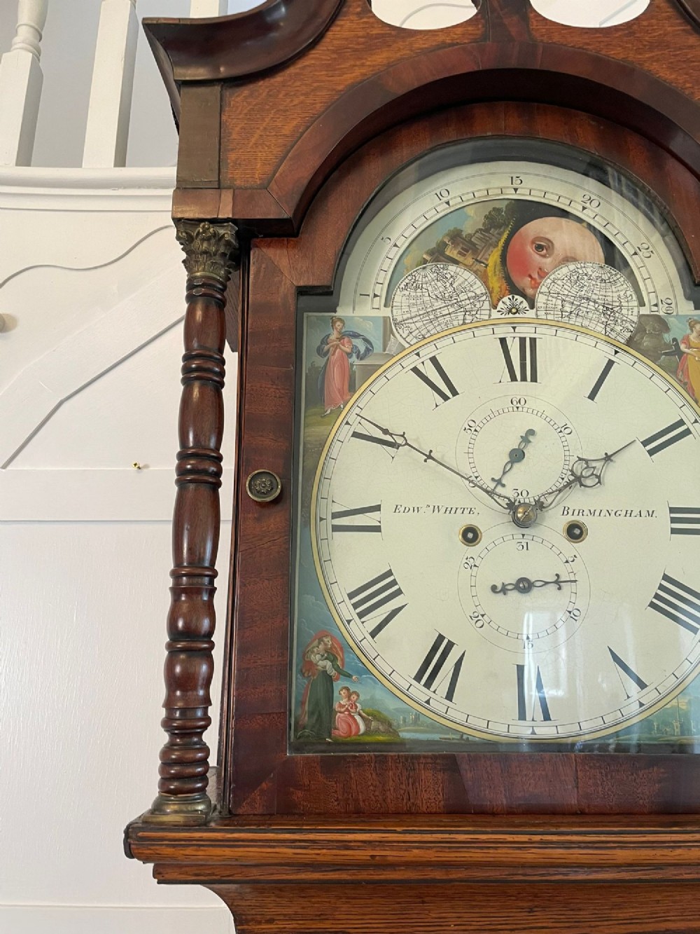 An antique George III oak and mahogany longcase clock with a swan-neck pediment, reeded columns, and a painted moon phase dial. View XIV