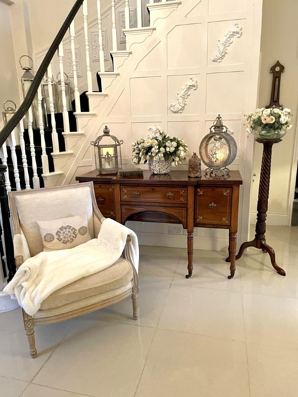 A Regency period mahogany breakfront sideboard featuring brass inlay motifs, a central drawer flanked by cupboards, turned legs, and brass castors. View III
