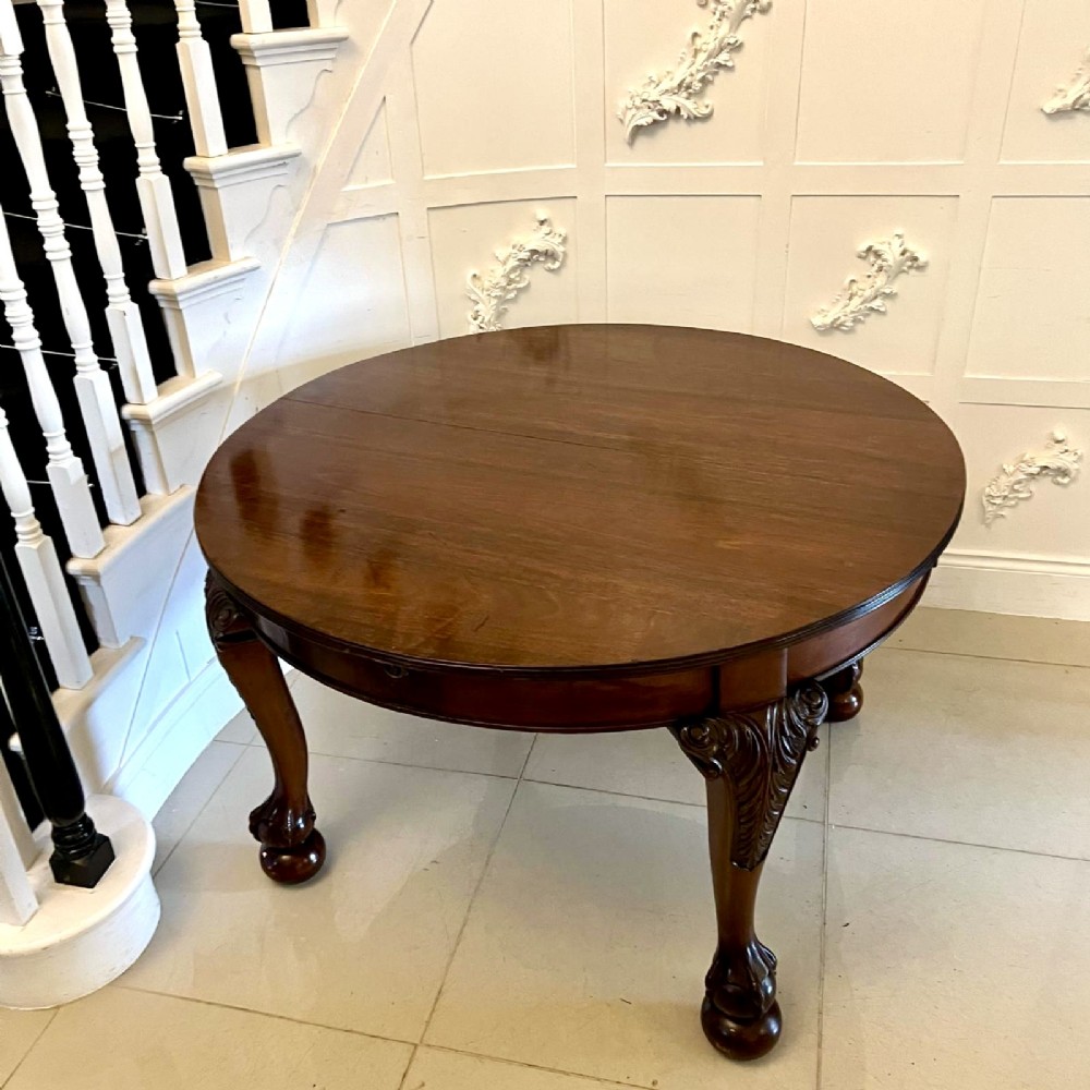 A large Victorian extending mahogany dining table featuring rounded ends and hand-carved cabriole legs with ball and claw feet. View II
