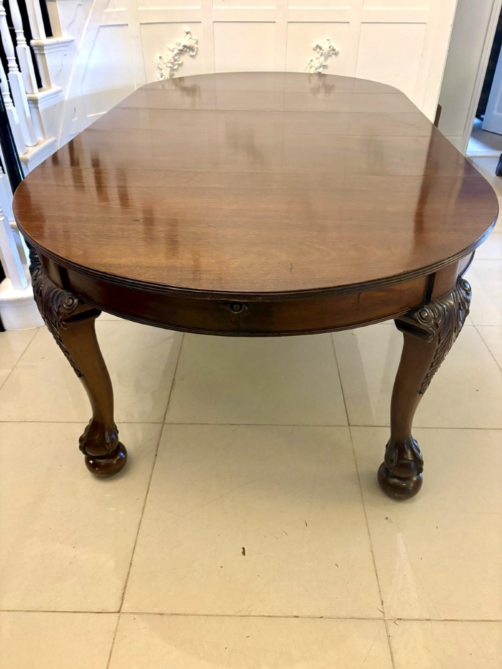A large Victorian extending mahogany dining table featuring rounded ends and hand-carved cabriole legs with ball and claw feet. View XI
