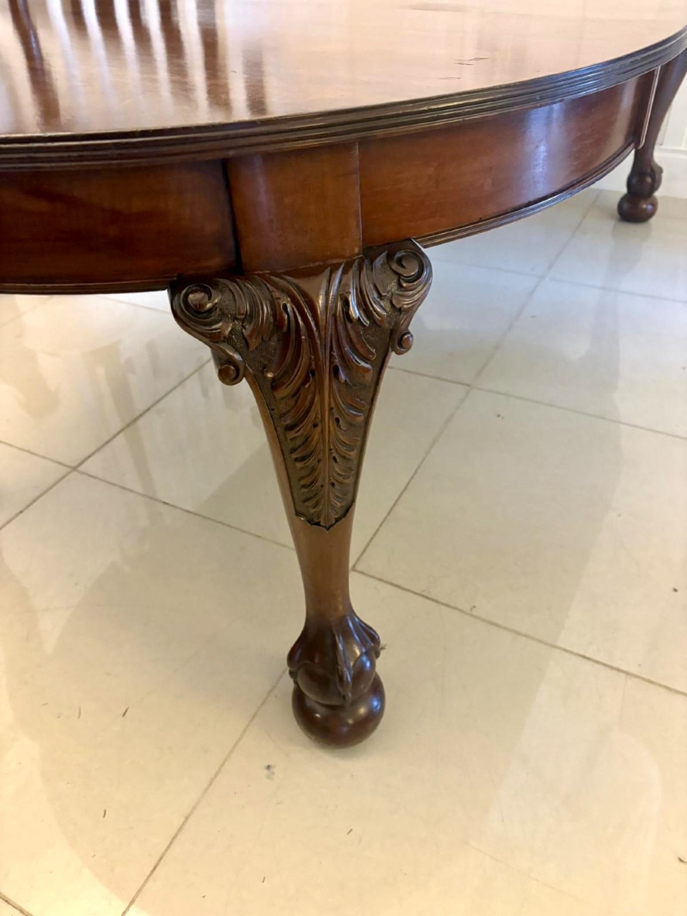 A large Victorian extending mahogany dining table featuring rounded ends and hand-carved cabriole legs with ball and claw feet. View XII