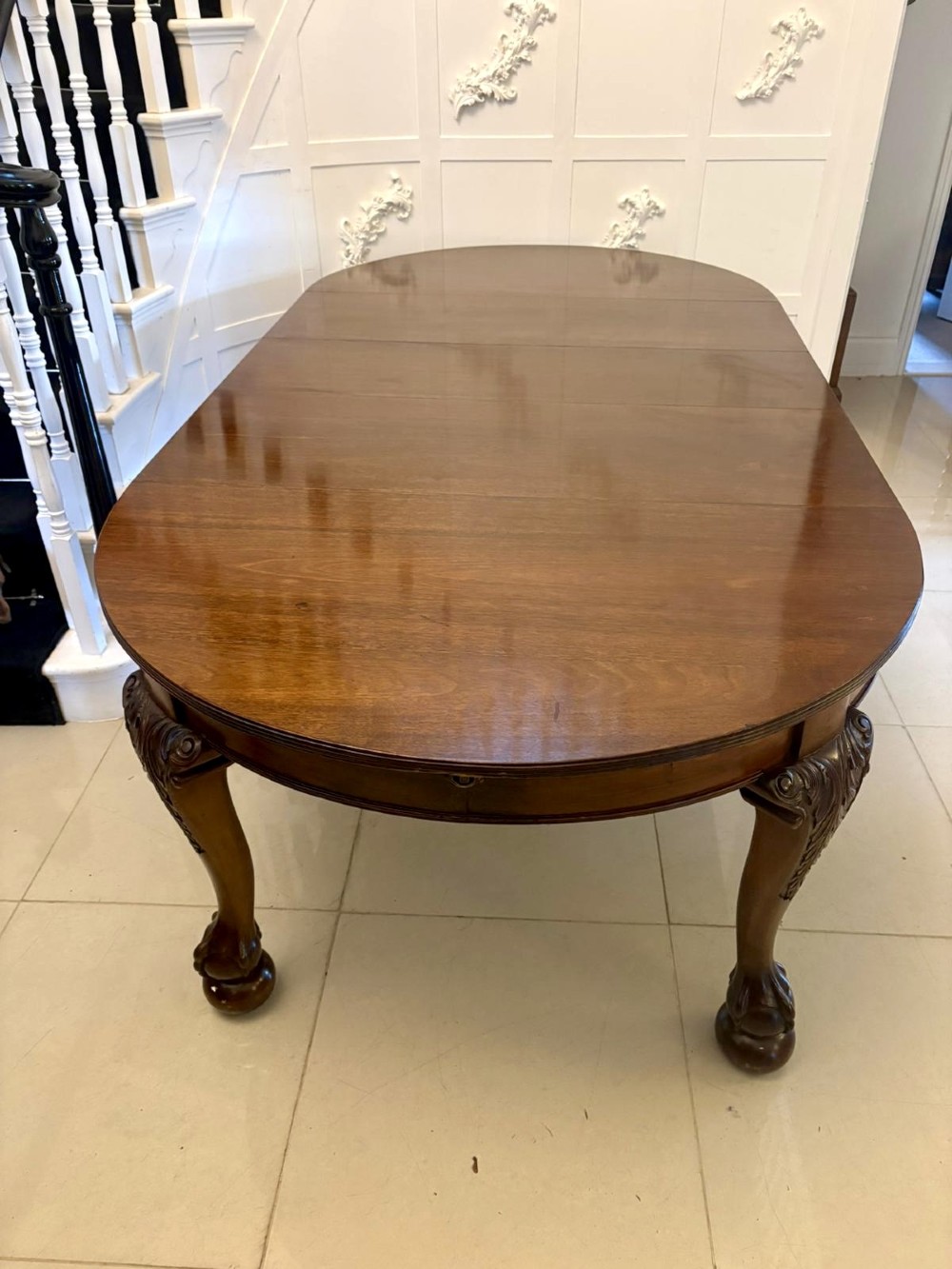 A large Victorian extending mahogany dining table featuring rounded ends and hand-carved cabriole legs with ball and claw feet. View XIII