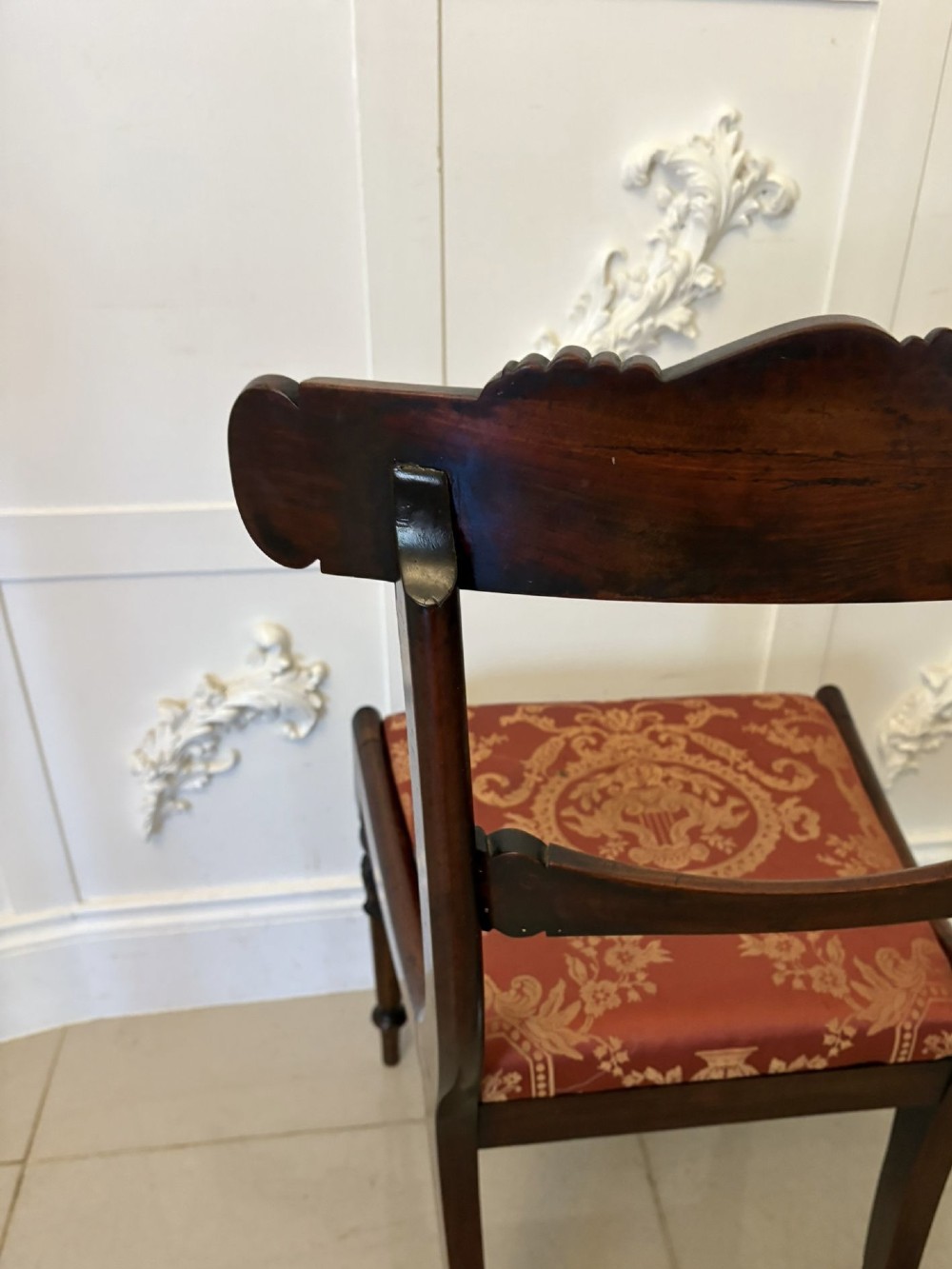 A set of six Regency carved rosewood dining chairs featuring curved backrests with scroll details, turned front legs, and pattern-upholstered seats. View IV