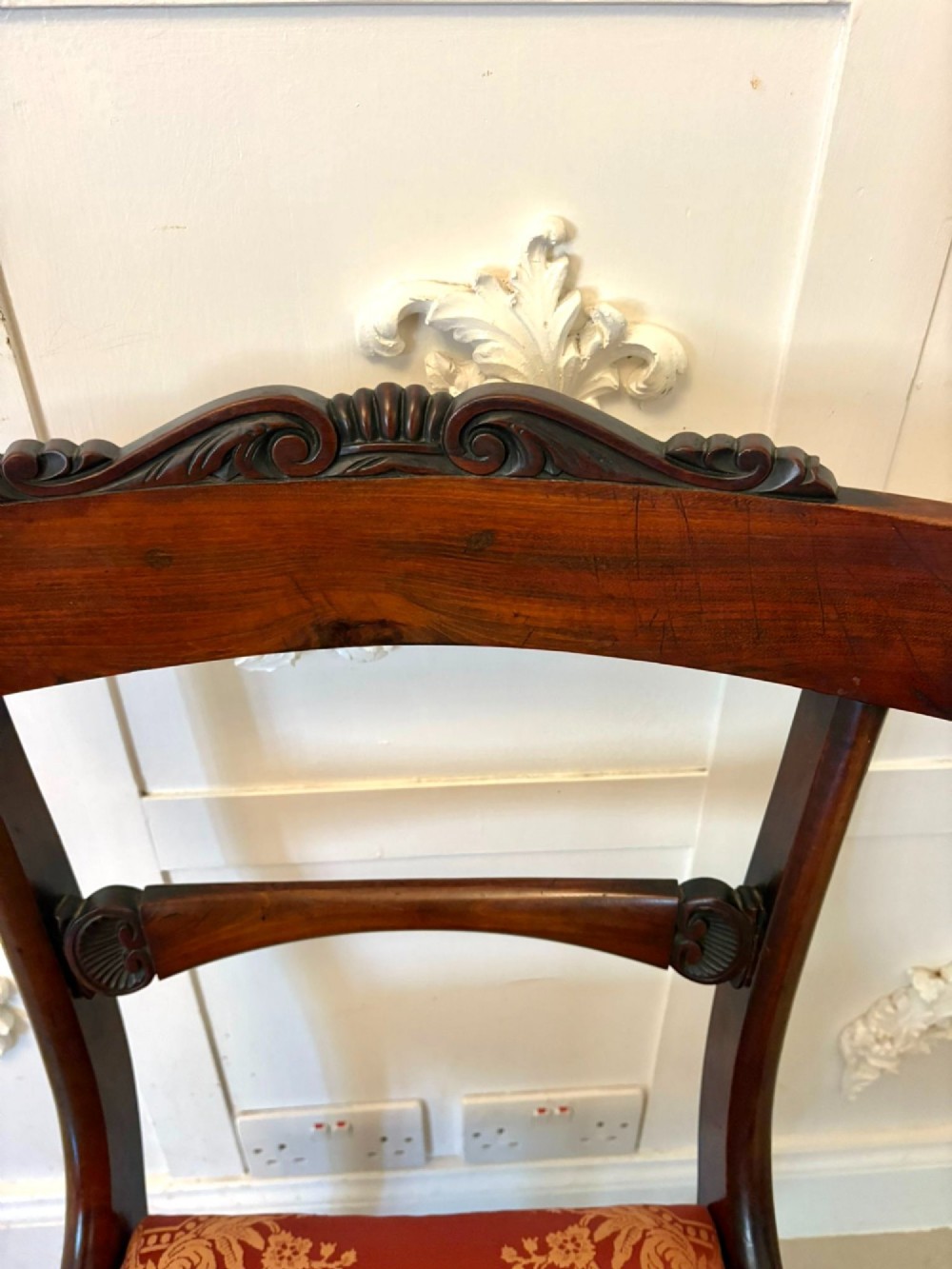 A set of six Regency carved rosewood dining chairs featuring curved backrests with scroll details, turned front legs, and pattern-upholstered seats. View VII
