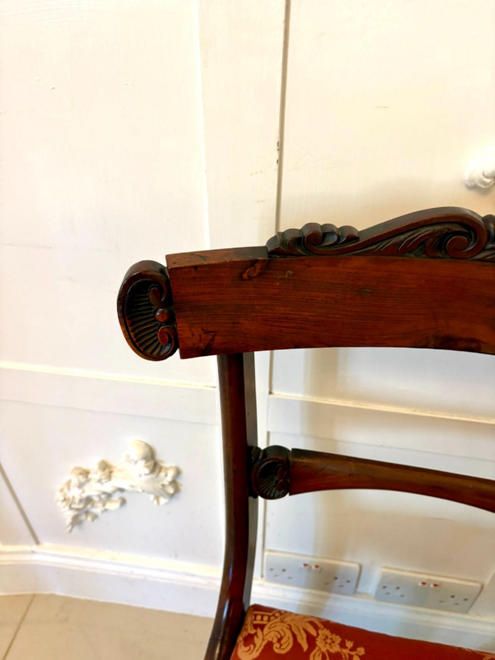 A set of six Regency carved rosewood dining chairs featuring curved backrests with scroll details, turned front legs, and pattern-upholstered seats. View VIII