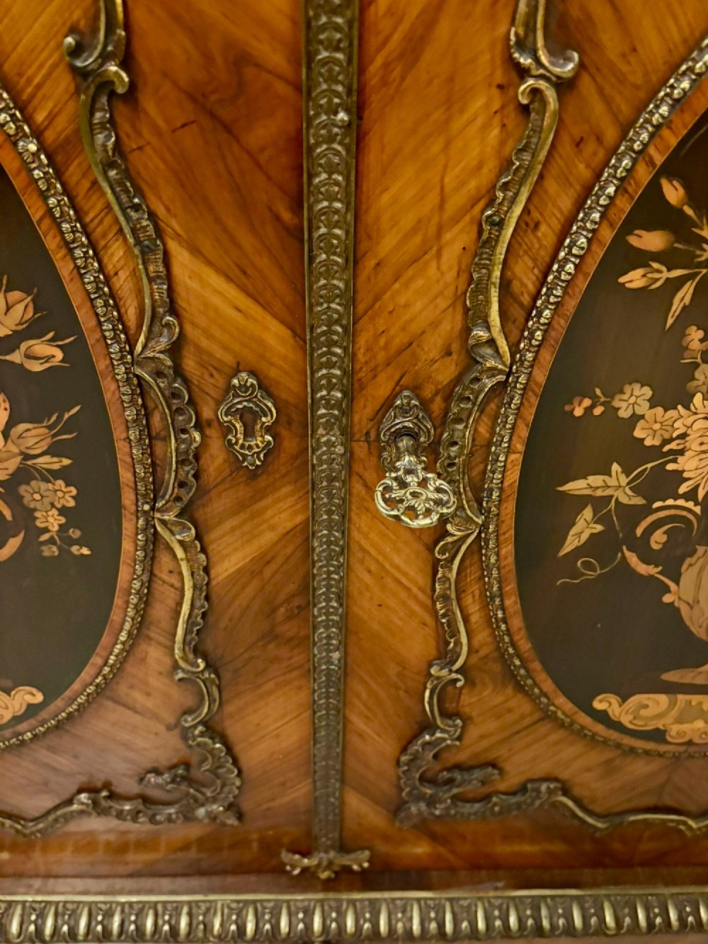 A French Louis XVI style wooden side cabinet featuring a white marble top, gilt-bronze mounts, and two door panels decorated with floral marquetry. View IV
