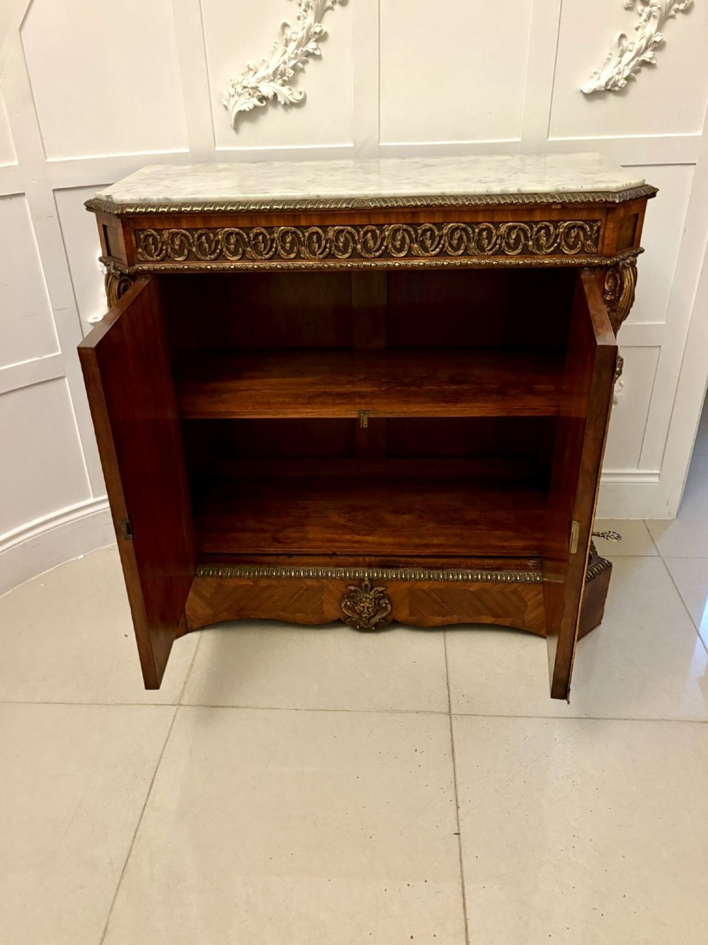 A French Louis XVI style wooden side cabinet featuring a white marble top, gilt-bronze mounts, and two door panels decorated with floral marquetry. View V