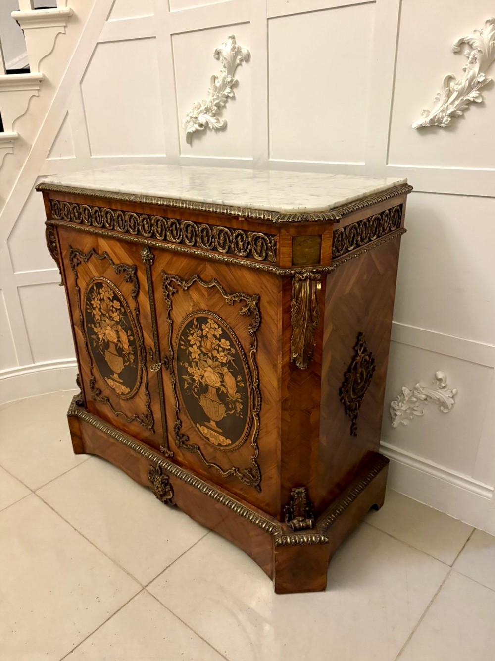 A French Louis XVI style wooden side cabinet featuring a white marble top, gilt-bronze mounts, and two door panels decorated with floral marquetry. View XIV