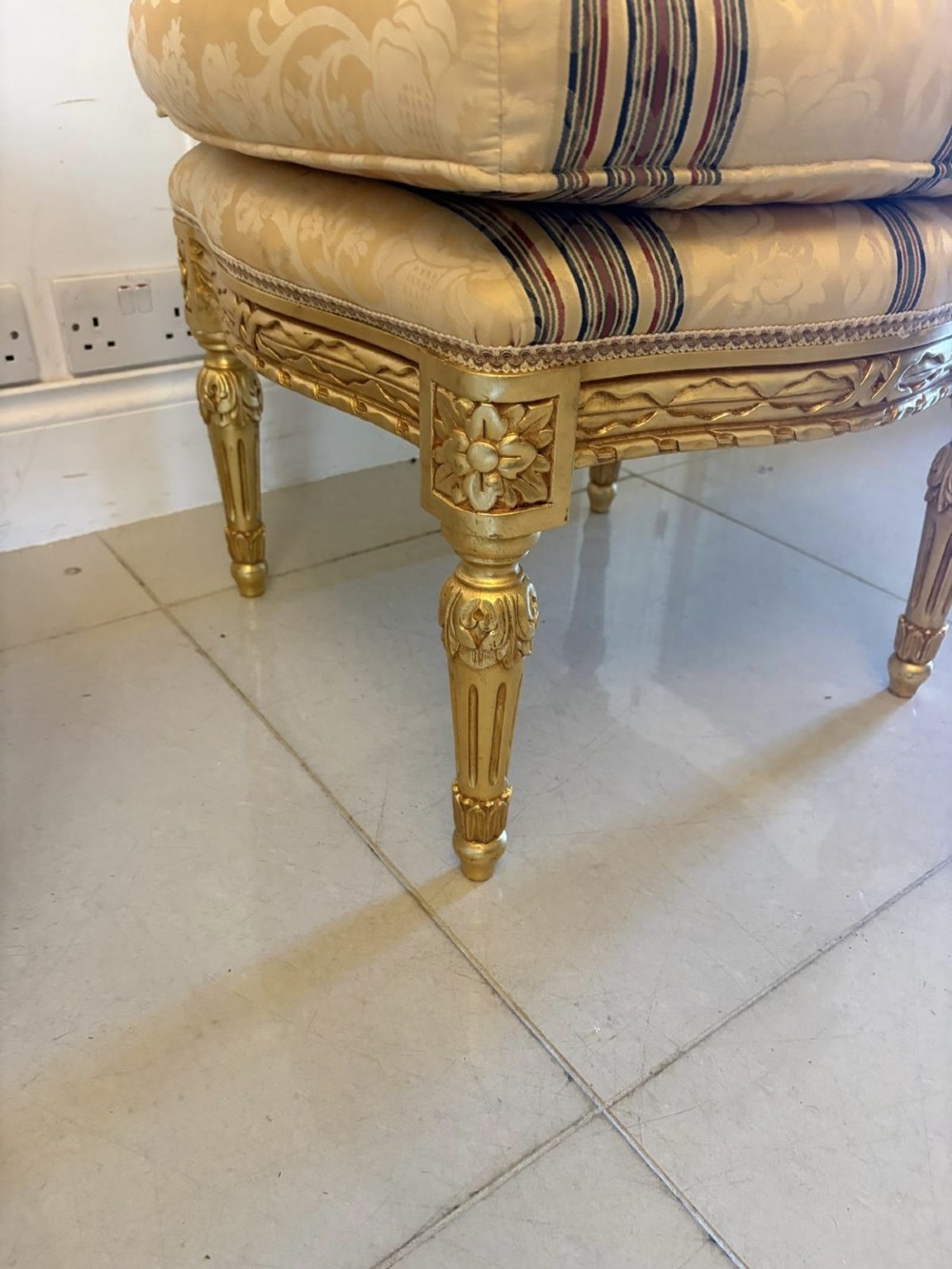 A pair of square French style footstools featuring carved gold giltwood frames, fluted legs, and yellow patterned upholstery. View XI