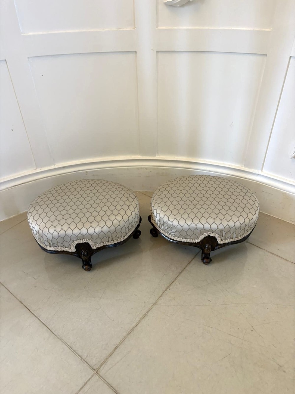 An eleven-piece antique Victorian carved walnut salon suite featuring a central sofa, pair of armchairs, six side chairs, and two footstools, all upholstered in a patterned cream fabric. View III