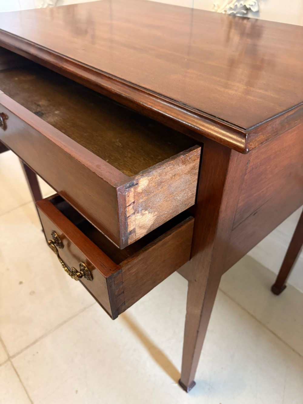An antique Georgian mahogany lowboy hall table featuring three drawers with brass swan-neck handles and straight square legs. View VI