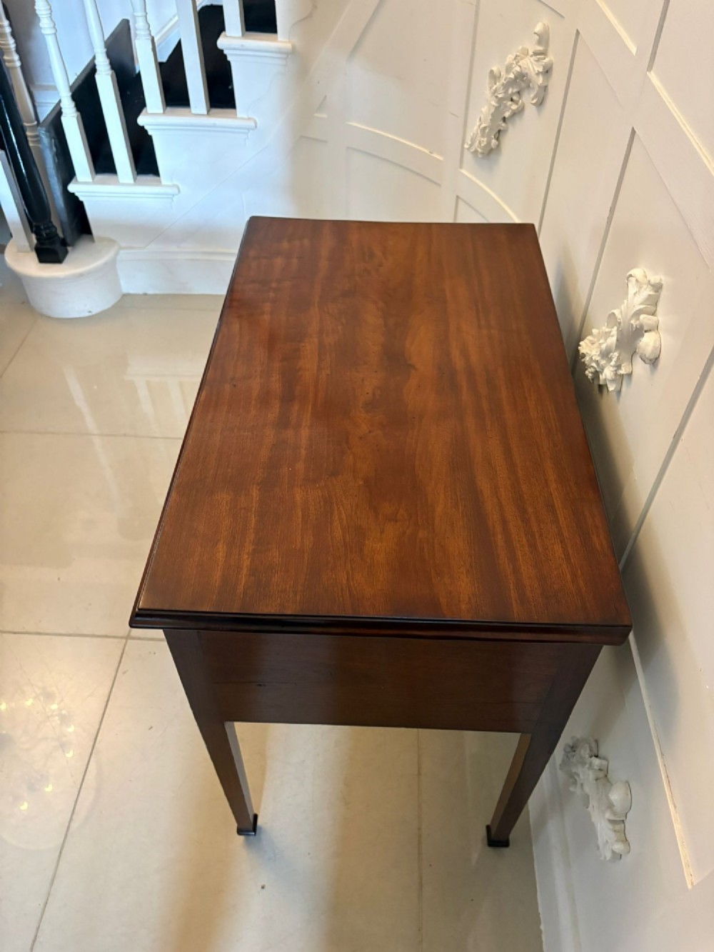 An antique Georgian mahogany lowboy hall table featuring three drawers with brass swan-neck handles and straight square legs. View IX