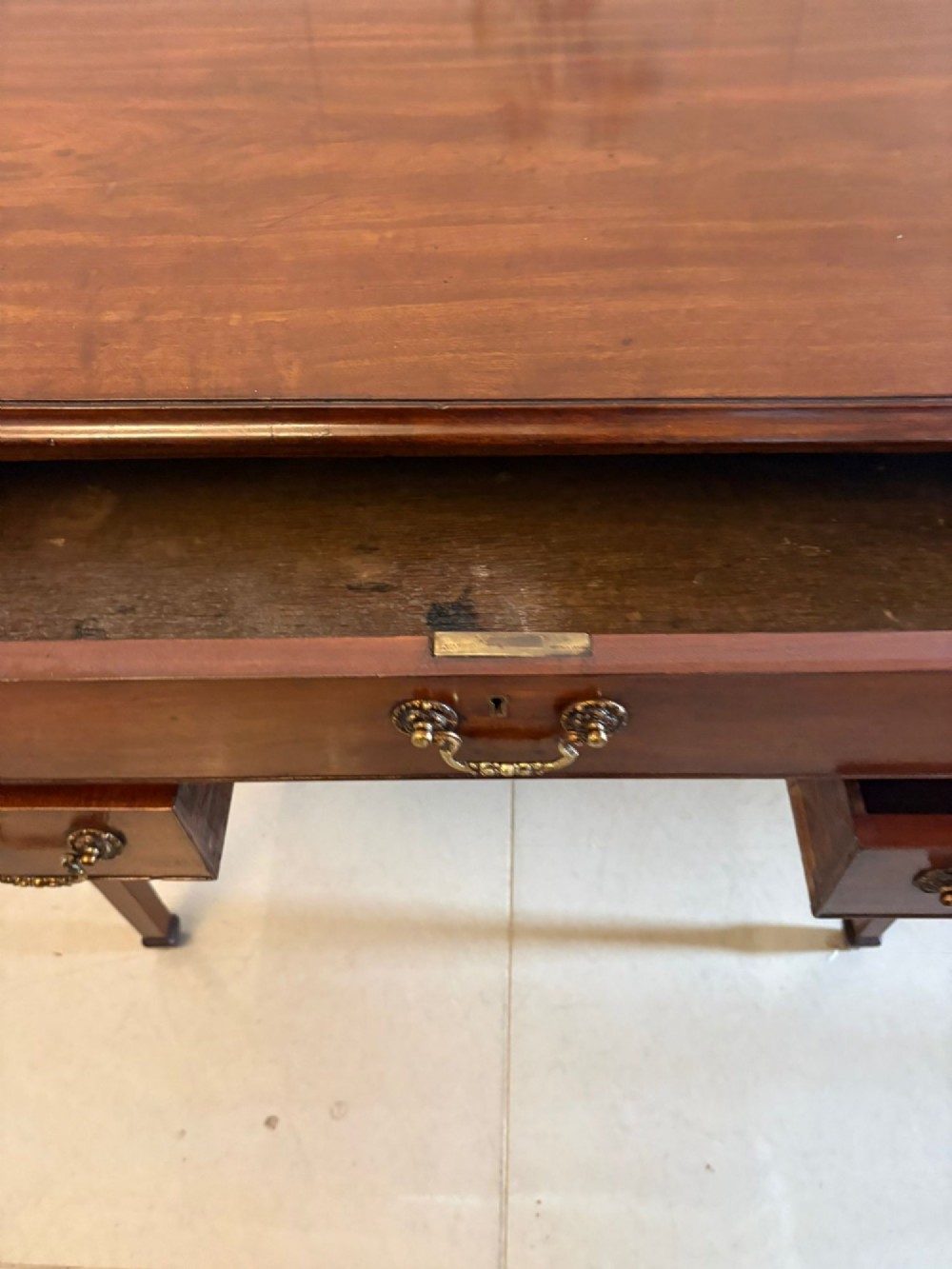 An antique Georgian mahogany lowboy hall table featuring three drawers with brass swan-neck handles and straight square legs. View XIV
