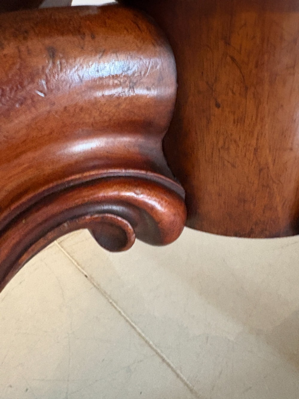 An oval Victorian tilt-top dining table in figured mahogany with satinwood crossbanding, set on a quadruped pedestal base with brass castors. View VII