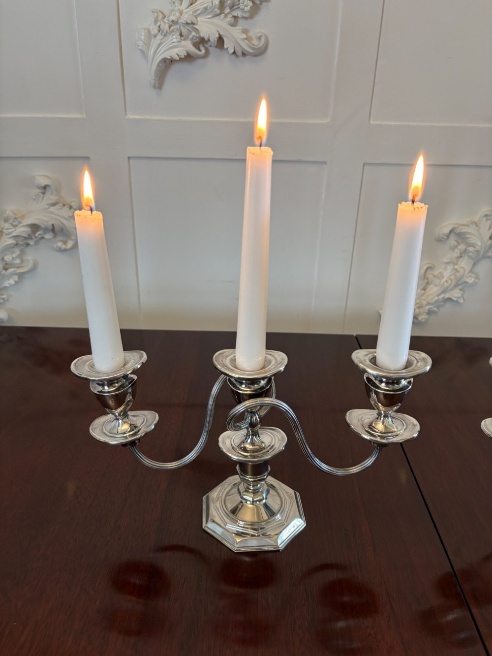 A matching pair of Edwardian silver plated three-light candelabras with octagonal bases and curved reeded arms. View IV