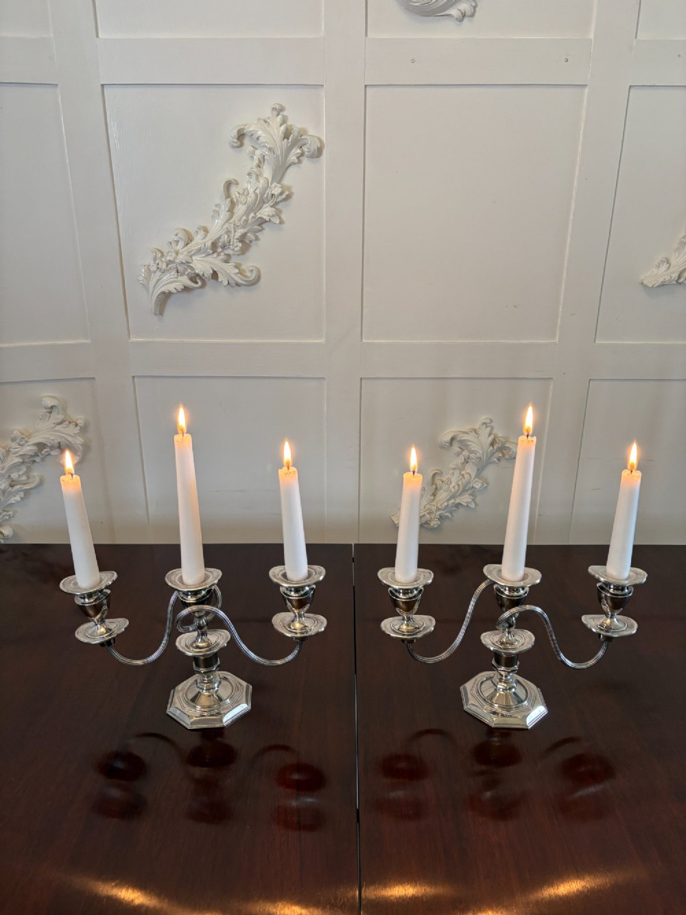A matching pair of Edwardian silver plated three-light candelabras with octagonal bases and curved reeded arms. View V