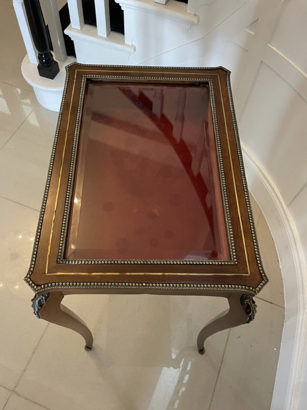 A 19th-century French mahogany bijouterie display table featuring a glazed top with brass inlay, a single front drawer, and slender cabriole legs with brass mounts. View III