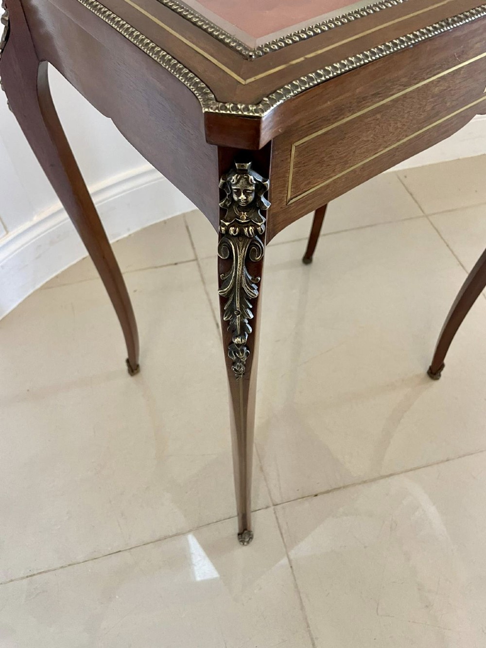 A 19th-century French mahogany bijouterie display table featuring a glazed top with brass inlay, a single front drawer, and slender cabriole legs with brass mounts. View VIII