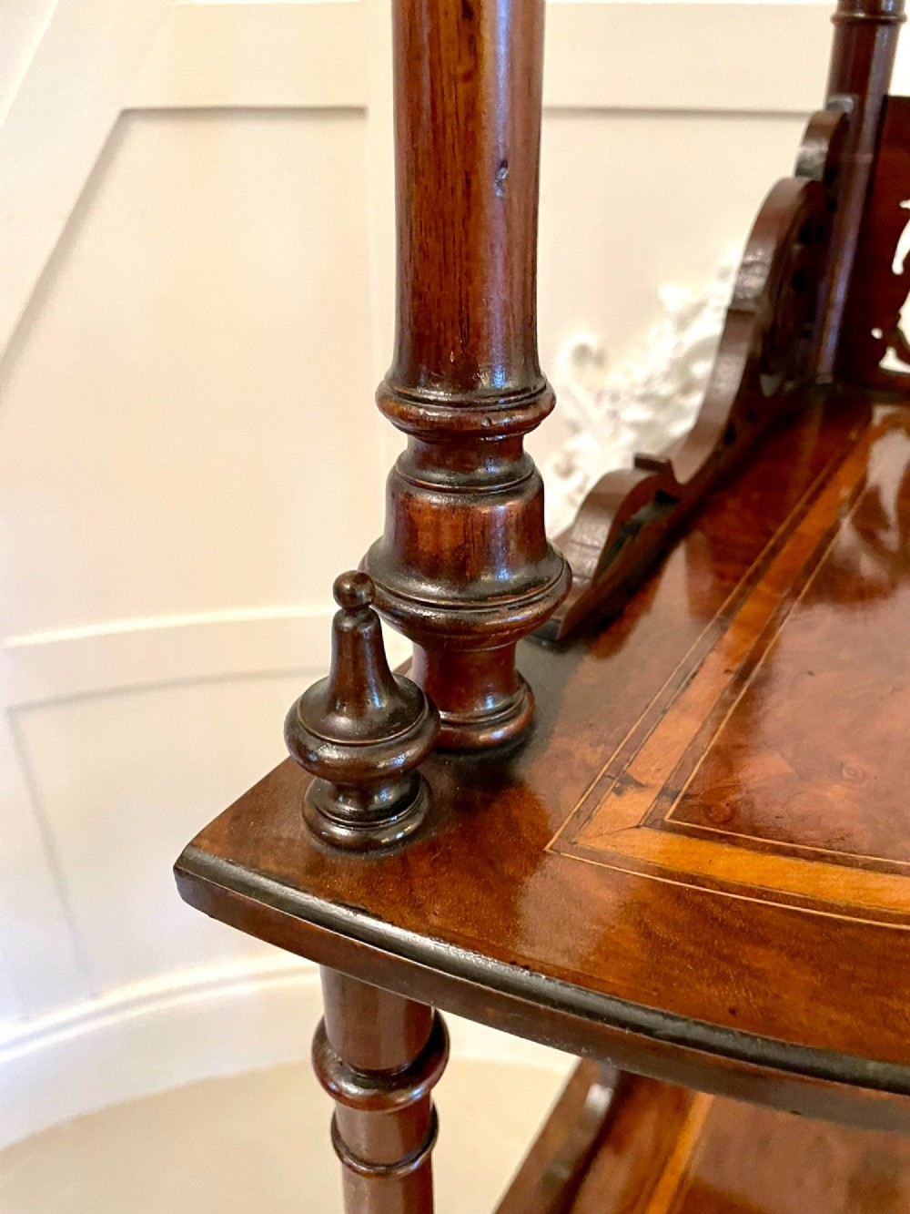 A four-tiered Victorian corner whatnot made of figured burr walnut featuring marquetry inlay, turned columns, and pierced fretwork crests. View V
