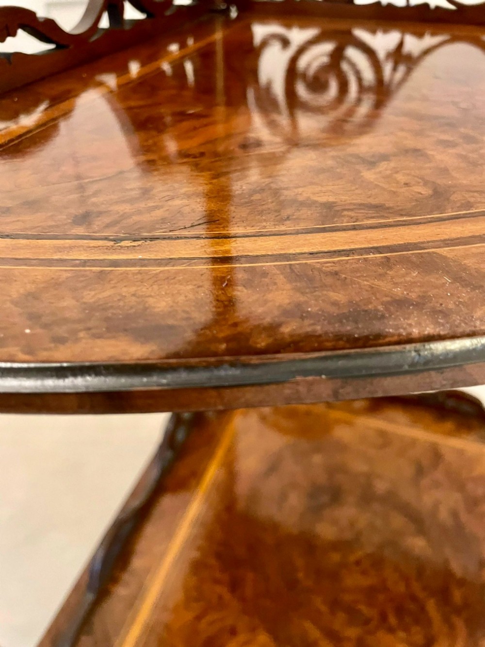 A four-tiered Victorian corner whatnot made of figured burr walnut featuring marquetry inlay, turned columns, and pierced fretwork crests. View VI