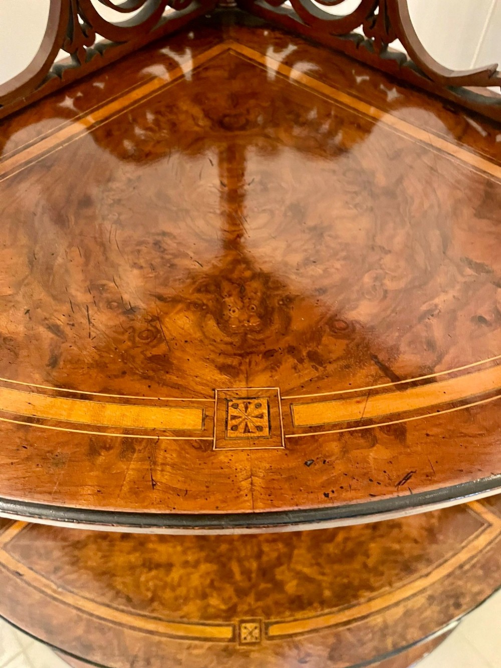 A four-tiered Victorian corner whatnot made of figured burr walnut featuring marquetry inlay, turned columns, and pierced fretwork crests. View XII