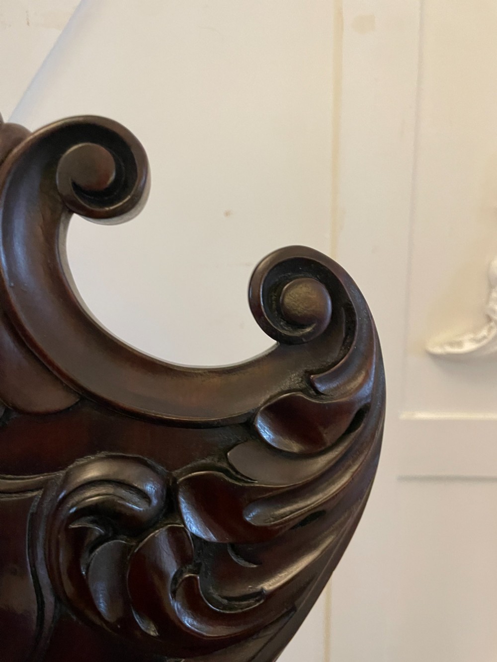 A pair of antique Regency dark mahogany hall chairs featuring scroll-carved cartouche backrests, solid timber seats, and reeded front legs. View IX