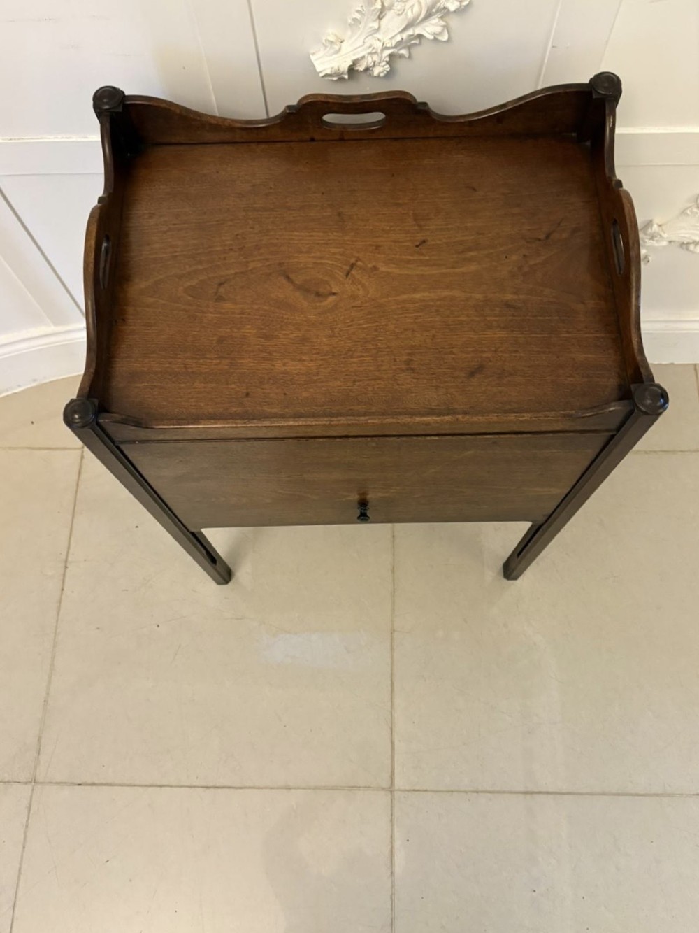 An 18th-century Georgian mahogany bedside cabinet featuring a gallery tray top with cut-out handles, a front cupboard door, and square legs. View III