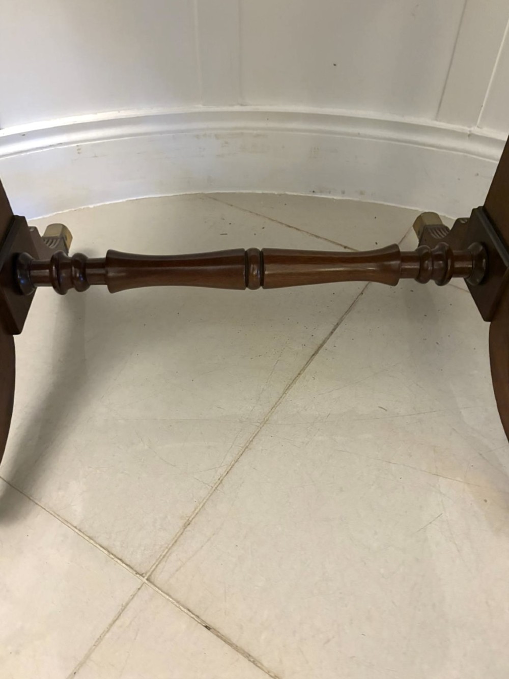 A Regency period mahogany sofa table featuring two drop-leaf sides, a single drawer with brass ring handles, reeded splayed legs, a turned stretcher bar, and brass castors. View V