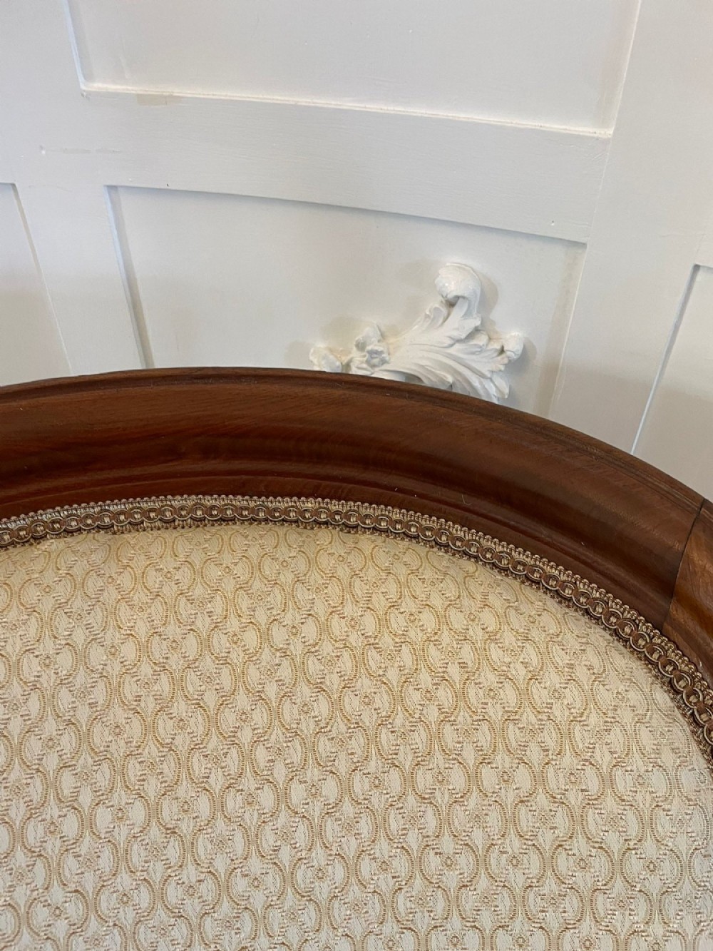 A pair of antique Victorian mahogany armchairs featuring carved show-frames, cream patterned upholstery, and turned front legs on castors. View III