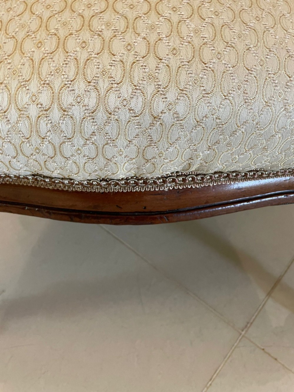 A pair of antique Victorian mahogany armchairs featuring carved show-frames, cream patterned upholstery, and turned front legs on castors. View IV