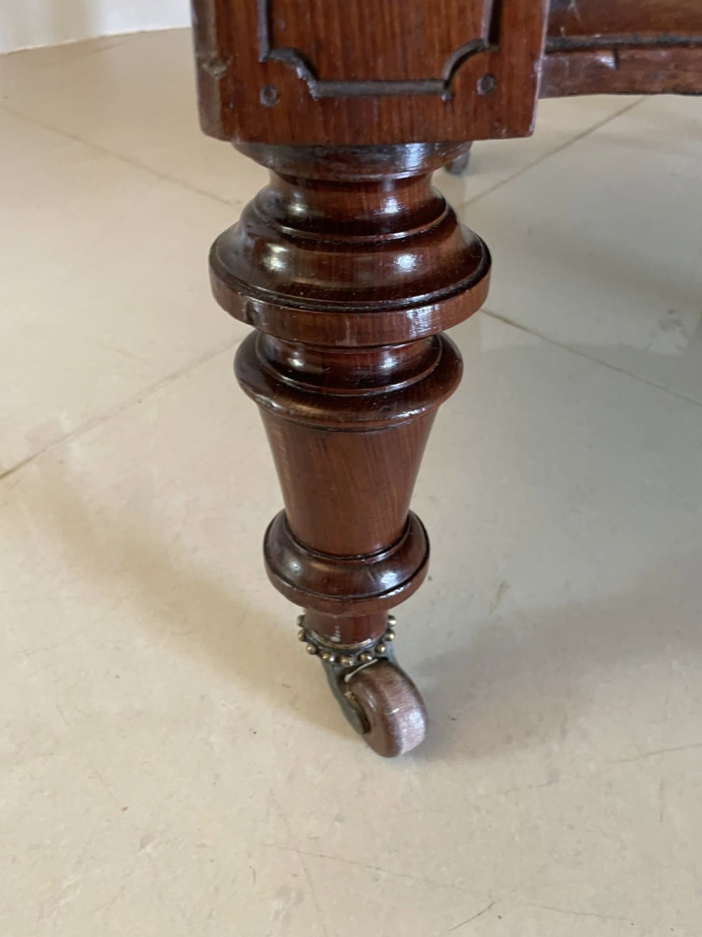 A pair of antique Victorian mahogany armchairs featuring carved show-frames, cream patterned upholstery, and turned front legs on castors. View IX