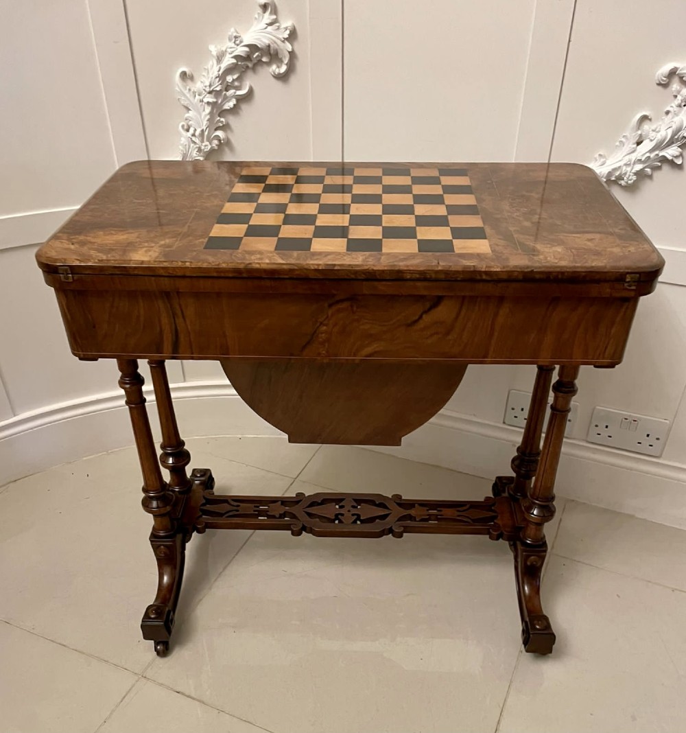 An antique Victorian burr walnut games table featuring an inlaid chessboard top, a frieze drawer, carved turned twin-column supports, and a pierced fretwork stretcher. View XII