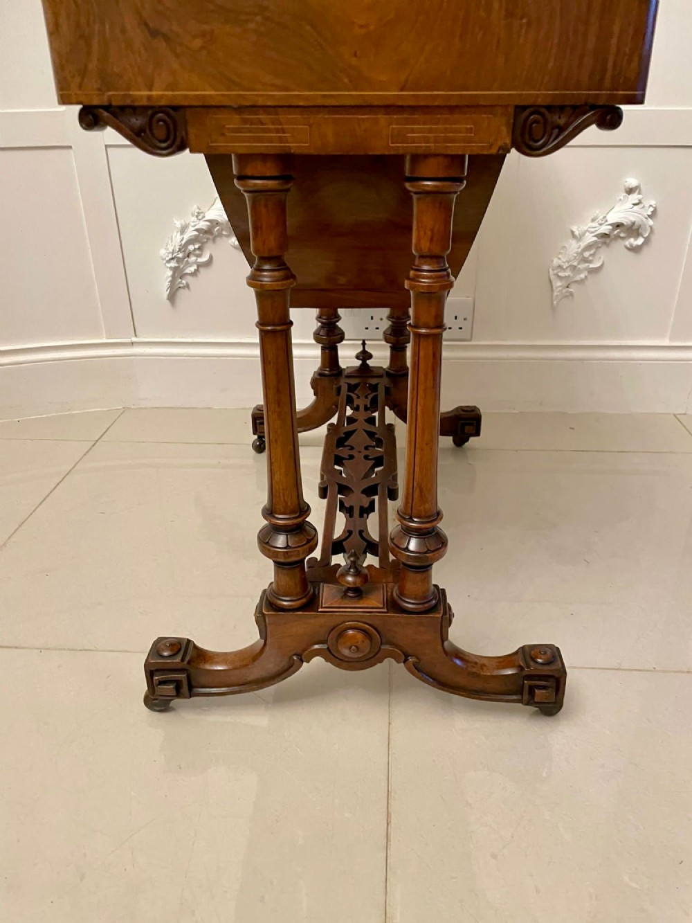 An antique Victorian burr walnut games table featuring an inlaid chessboard top, a frieze drawer, carved turned twin-column supports, and a pierced fretwork stretcher. View XV